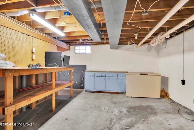 basement featuring a workshop area and white refrigerator