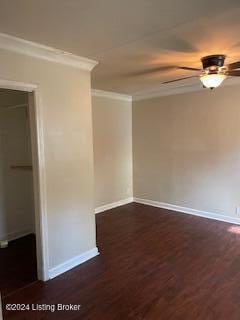 empty room featuring ornamental molding, dark wood-type flooring, and ceiling fan