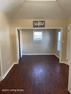 spare room with lofted ceiling and dark hardwood / wood-style flooring