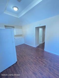 empty room featuring ornamental molding, dark hardwood / wood-style floors, and a tray ceiling