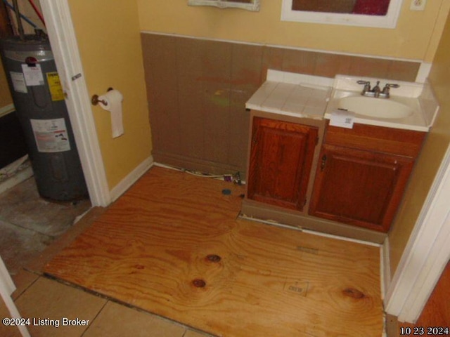 bathroom with vanity, water heater, and tile patterned flooring