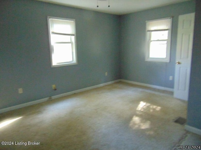 carpeted spare room featuring ceiling fan and a healthy amount of sunlight