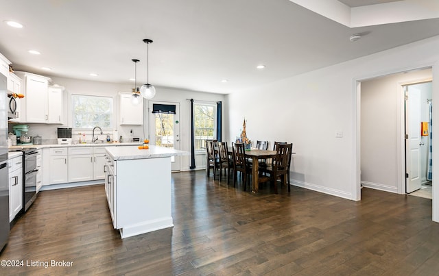 kitchen featuring a healthy amount of sunlight, appliances with stainless steel finishes, pendant lighting, and a kitchen island