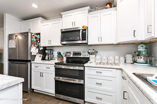 kitchen featuring appliances with stainless steel finishes, white cabinets, and dark hardwood / wood-style floors