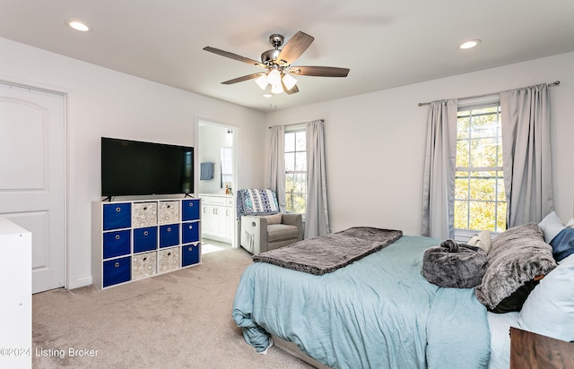 carpeted bedroom with ceiling fan and ensuite bath