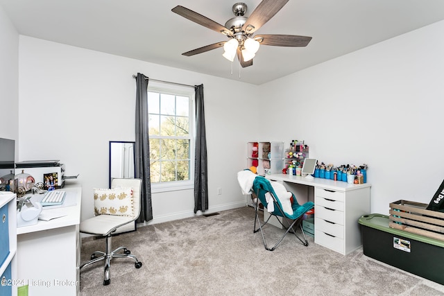 carpeted office space featuring ceiling fan