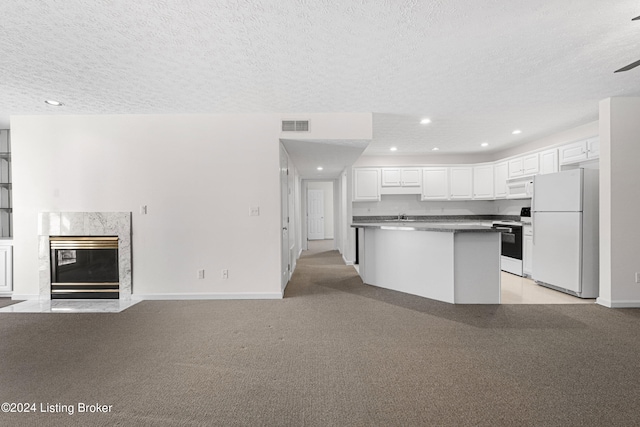 kitchen featuring a premium fireplace, a textured ceiling, white cabinetry, light colored carpet, and white appliances