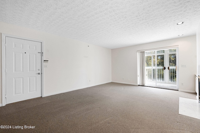 carpeted empty room with a textured ceiling