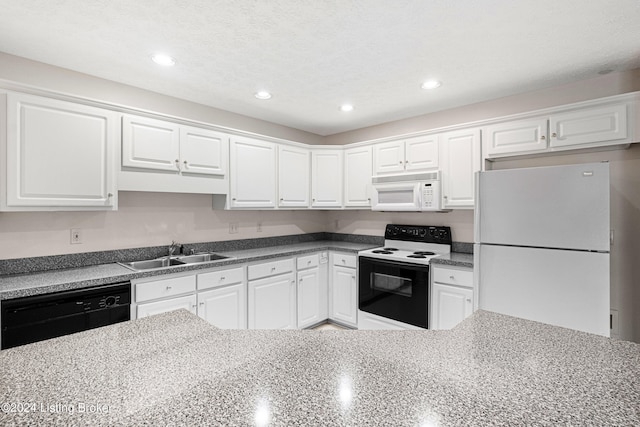 kitchen with white appliances, sink, a textured ceiling, white cabinets, and dark stone countertops