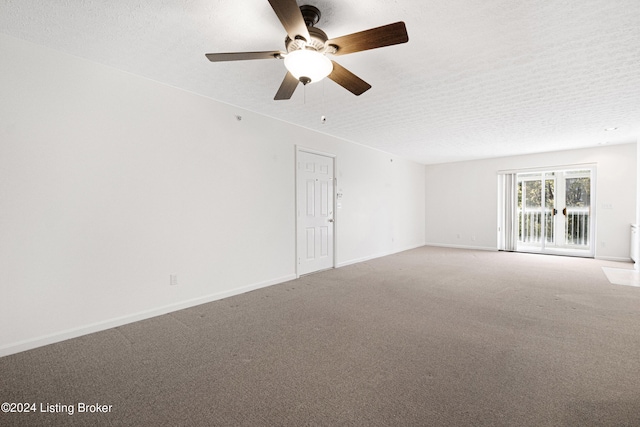 spare room featuring ceiling fan, carpet, and a textured ceiling