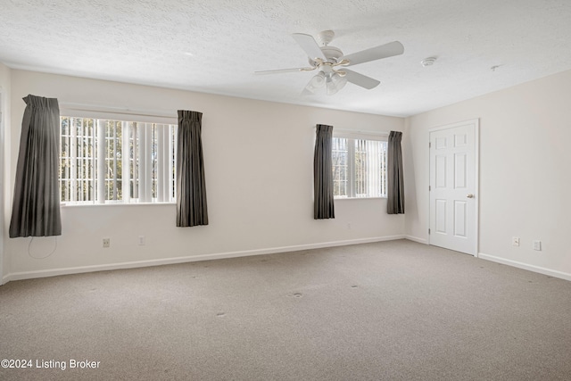 carpeted spare room with a textured ceiling and ceiling fan