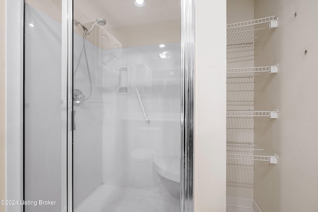 bathroom featuring tile patterned floors, toilet, and an enclosed shower