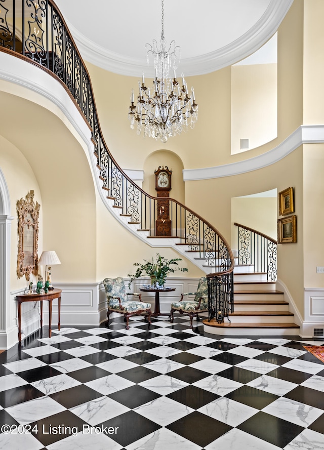 entrance foyer featuring a towering ceiling and ornamental molding