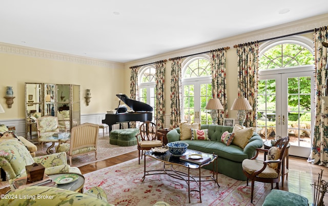 living room featuring french doors, light hardwood / wood-style flooring, crown molding, and plenty of natural light