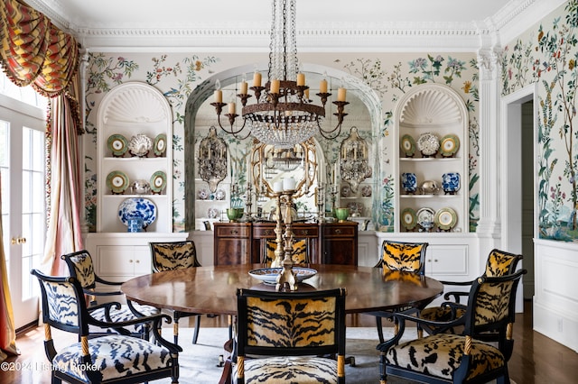 dining room featuring crown molding, hardwood / wood-style floors, a notable chandelier, and built in shelves