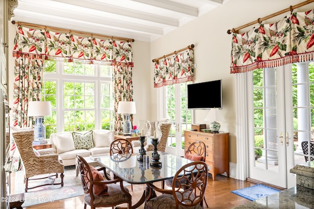 dining space featuring beam ceiling, wood-type flooring, and a healthy amount of sunlight