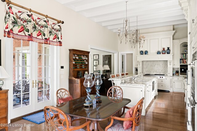 dining room with beam ceiling, dark wood-type flooring, and an inviting chandelier