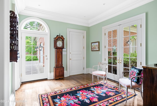 interior space with french doors, crown molding, and light wood-type flooring