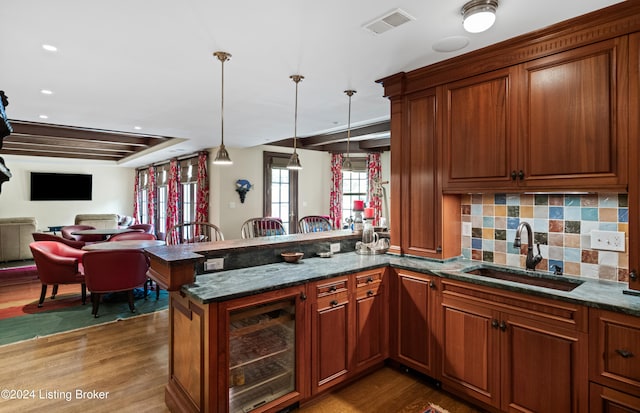 kitchen with decorative backsplash, beverage cooler, dark hardwood / wood-style floors, decorative light fixtures, and sink