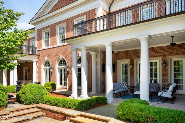 property entrance featuring a balcony, a patio, and ceiling fan