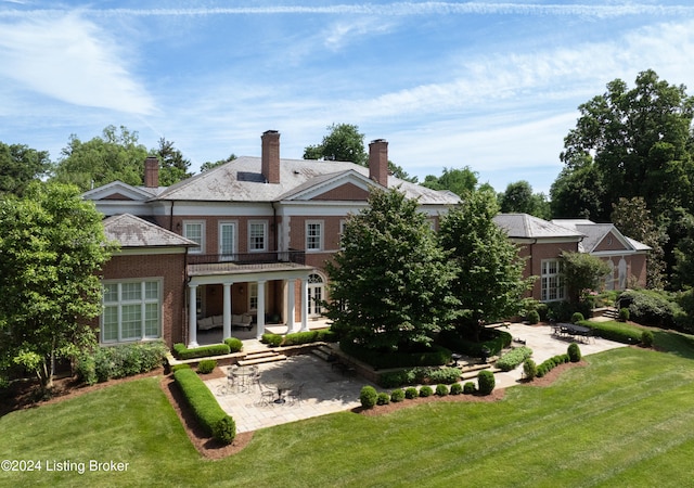 rear view of house featuring a yard and a patio area