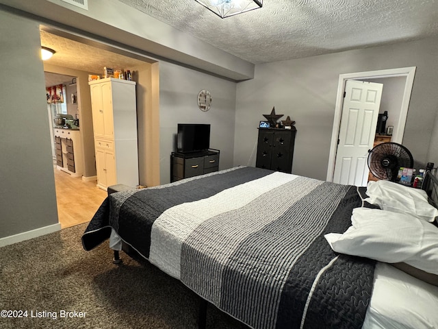 carpeted bedroom featuring a textured ceiling