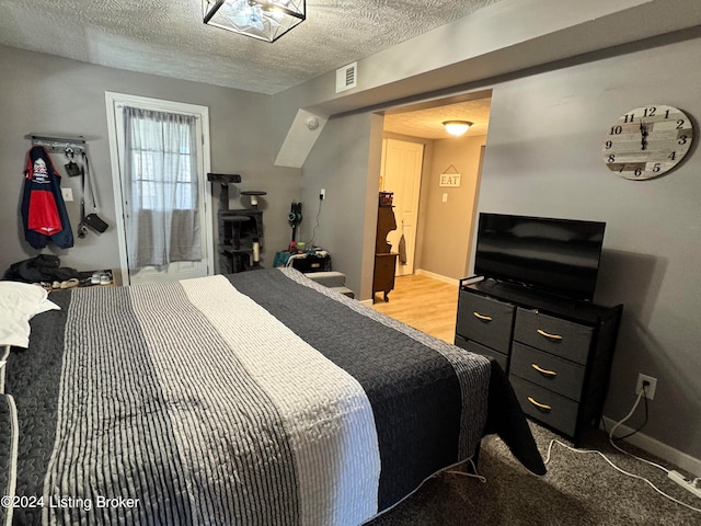 bedroom featuring a textured ceiling and wood-type flooring