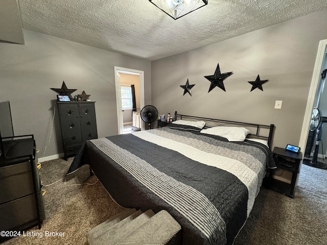 bedroom featuring a textured ceiling and dark carpet