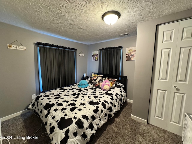 carpeted bedroom featuring a closet and a textured ceiling