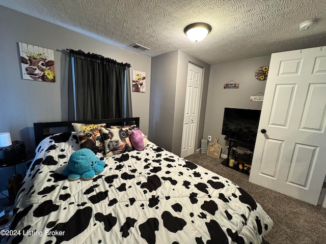 bedroom featuring a textured ceiling and carpet flooring