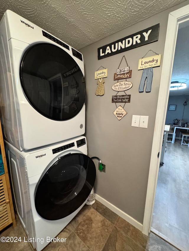 clothes washing area featuring stacked washer / dryer and a textured ceiling