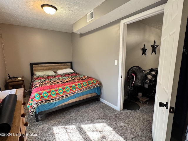 bedroom featuring carpet and a textured ceiling