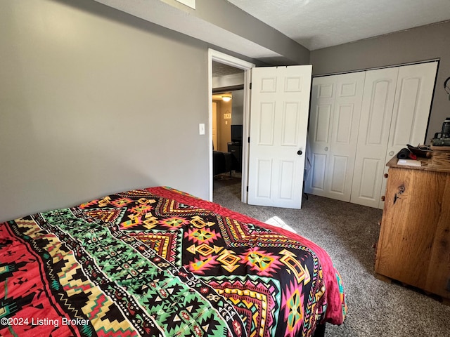 bedroom featuring a closet, a textured ceiling, and carpet