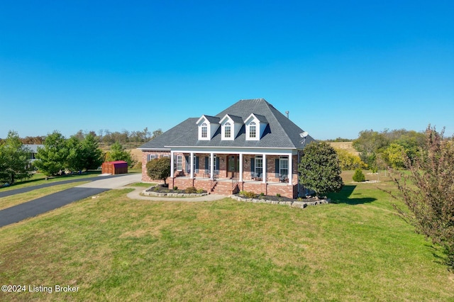 new england style home featuring a front yard and a porch