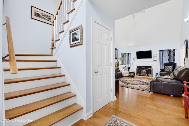 staircase with lofted ceiling and hardwood / wood-style floors