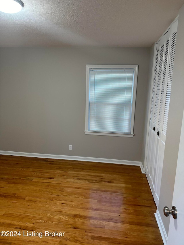 spare room featuring a textured ceiling and wood-type flooring