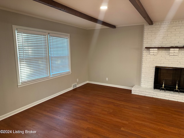 unfurnished living room featuring beamed ceiling, dark hardwood / wood-style flooring, a brick fireplace, and ornamental molding