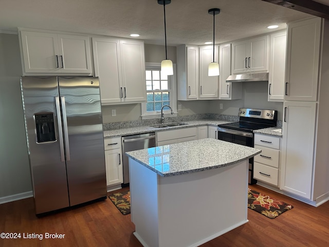 kitchen with hanging light fixtures, stainless steel appliances, sink, a center island, and white cabinets