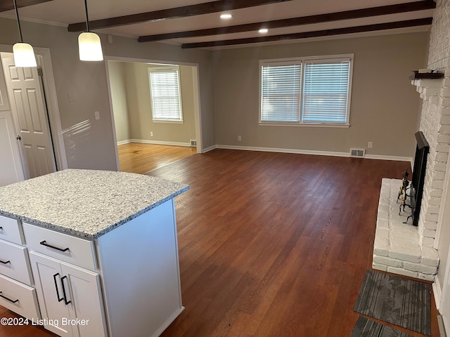 kitchen with white cabinetry, light stone counters, pendant lighting, and dark hardwood / wood-style floors