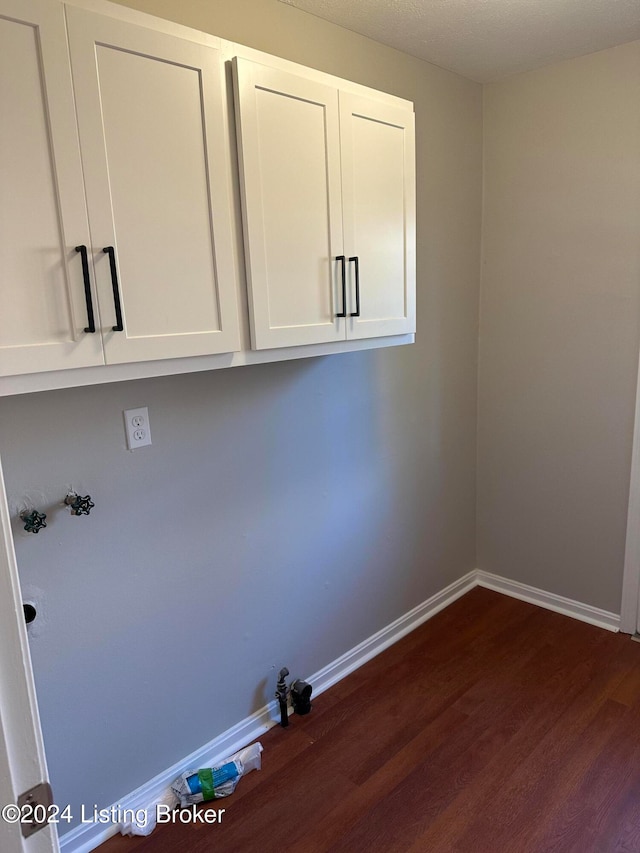 clothes washing area featuring hookup for a washing machine, cabinets, and dark hardwood / wood-style flooring