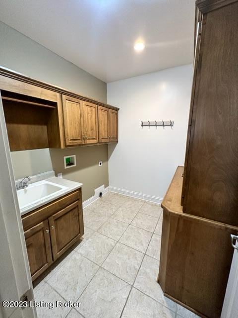 washroom featuring hookup for a washing machine, sink, electric dryer hookup, cabinets, and light tile patterned floors