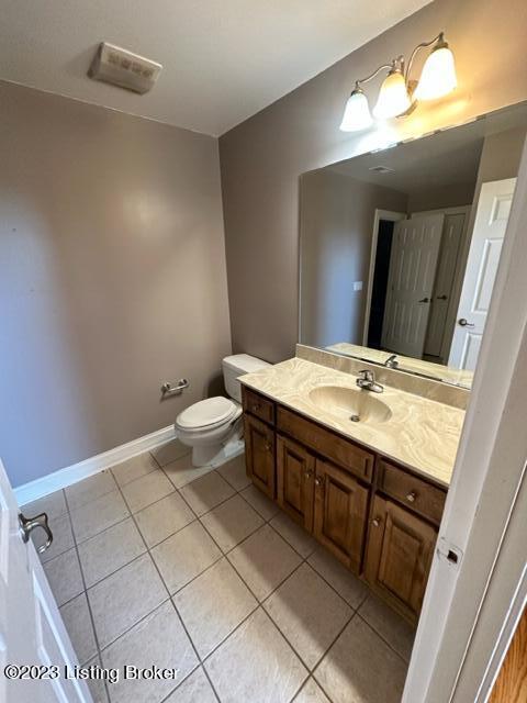 bathroom with vanity, toilet, and tile patterned floors