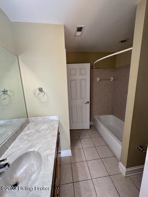 bathroom featuring vanity, tile patterned floors, and tiled shower / bath