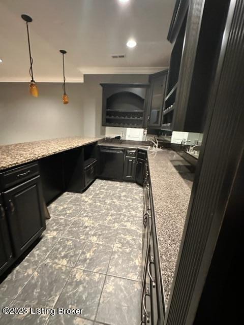 kitchen featuring ornamental molding, sink, light stone countertops, and hanging light fixtures