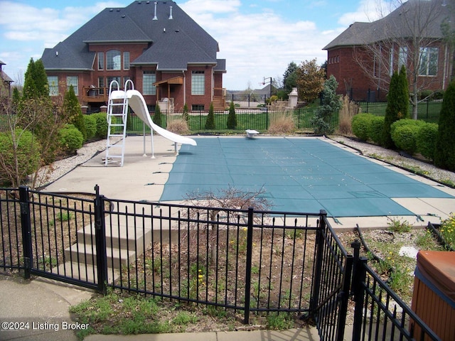 view of swimming pool with a patio area and a water slide