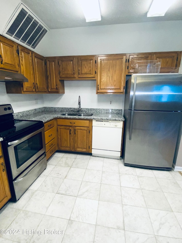 kitchen with stainless steel appliances, sink, and vaulted ceiling