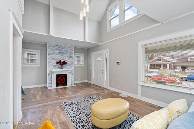 living room featuring hardwood / wood-style floors, high vaulted ceiling, and a large fireplace