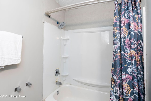 bathroom with a textured ceiling and shower / bath combo