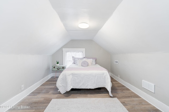 bedroom with wood-type flooring and lofted ceiling