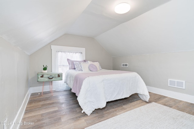 bedroom with hardwood / wood-style flooring and vaulted ceiling